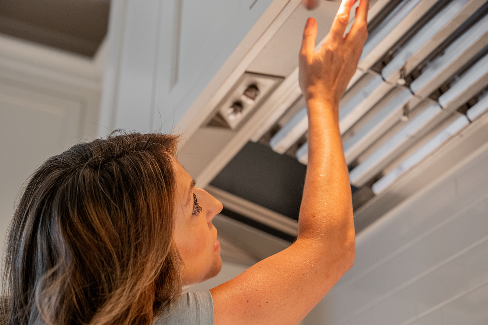 Vellamore house manager checking a ceiling fixture during a Home Watch visit on Kiawah Island, SC